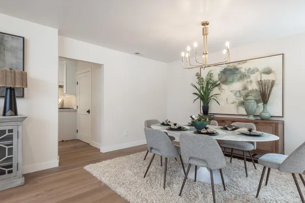 a view of a dining room with furniture wooden floor and a chandelier