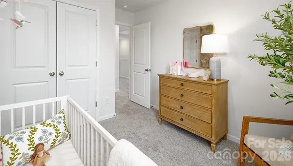 a bedroom with a bed and a lamp on dresser