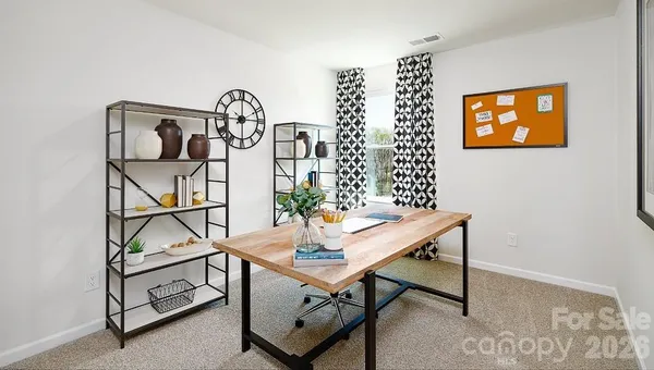 a view of a room that has a table and a potted plant on a table