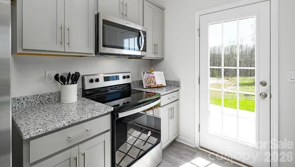 a kitchen with stainless steel appliances granite countertop a sink stove and cabinets