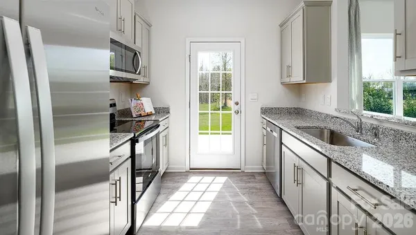 a kitchen with a sink a refrigerator and window