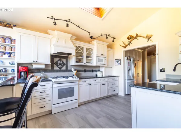 a large kitchen with stainless steel appliances kitchen island granite countertop a sink and cabinets
