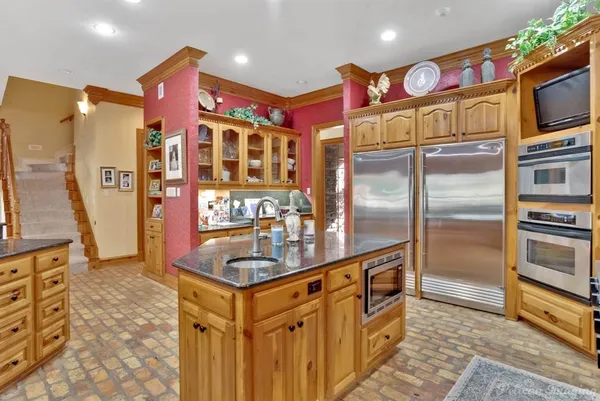 a kitchen with stainless steel appliances granite countertop a refrigerator and a sink