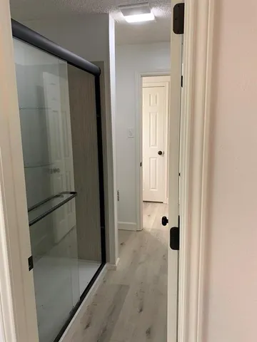 an empty room with wooden floor windows and closet