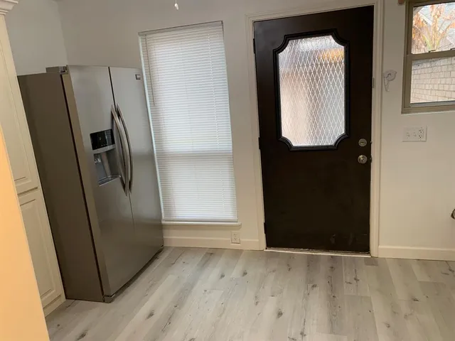 an empty room with wooden floor and door