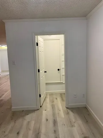 a view of a hallway with wooden floor and entryway