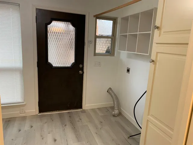 an empty room with wooden floor and cabinet