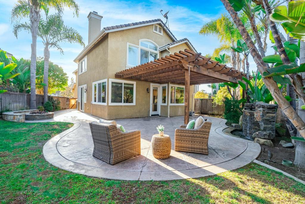 a view of a chair and table in backyard of the house