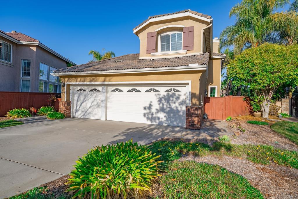 5406 Foxtail Loop Carlsbad, CA 92010 - Photo 34 of 50 a front view of a house with a yard and garage