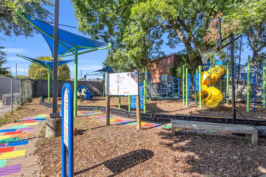 4121 Junius Street, Unit B Dallas, TX 75246 - Photo 6 of 32 Outdoor recreational area featuring a colorful playground, wood chip ground cover, and shade canopies