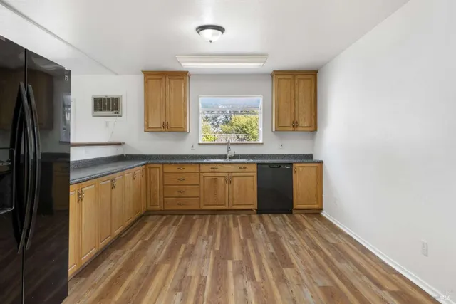 a large kitchen with a sink window and stainless steel appliances