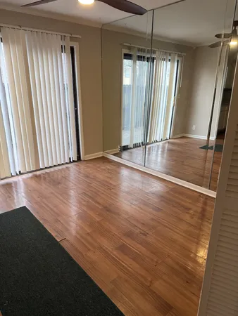 an empty room with wooden floor and windows