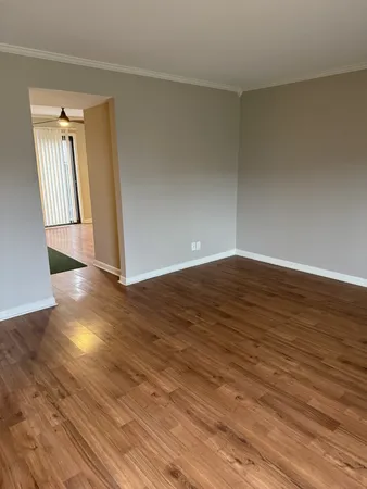 an empty room with wooden floor and door