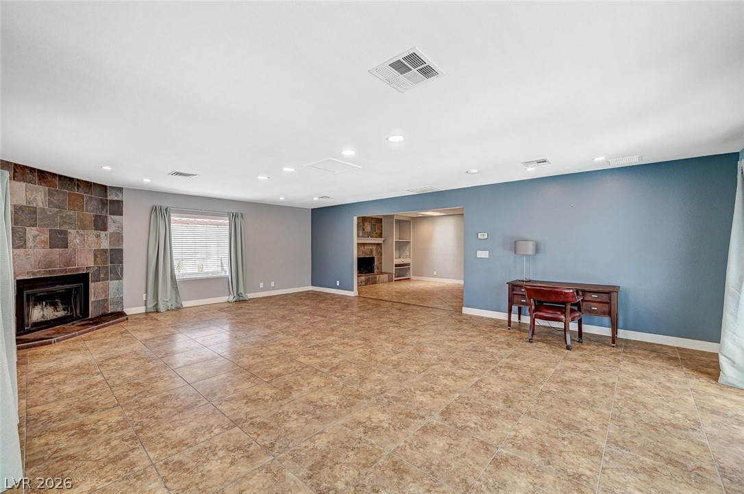 4153 Woodcrest Road Las Vegas, NV 89121 - Photo 21 of 58 A spacious living area featuring tiled floors, a stone fireplace, and recessed lighting.