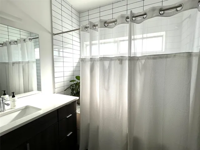 a bathroom with a shower and a double vanity sink mirror