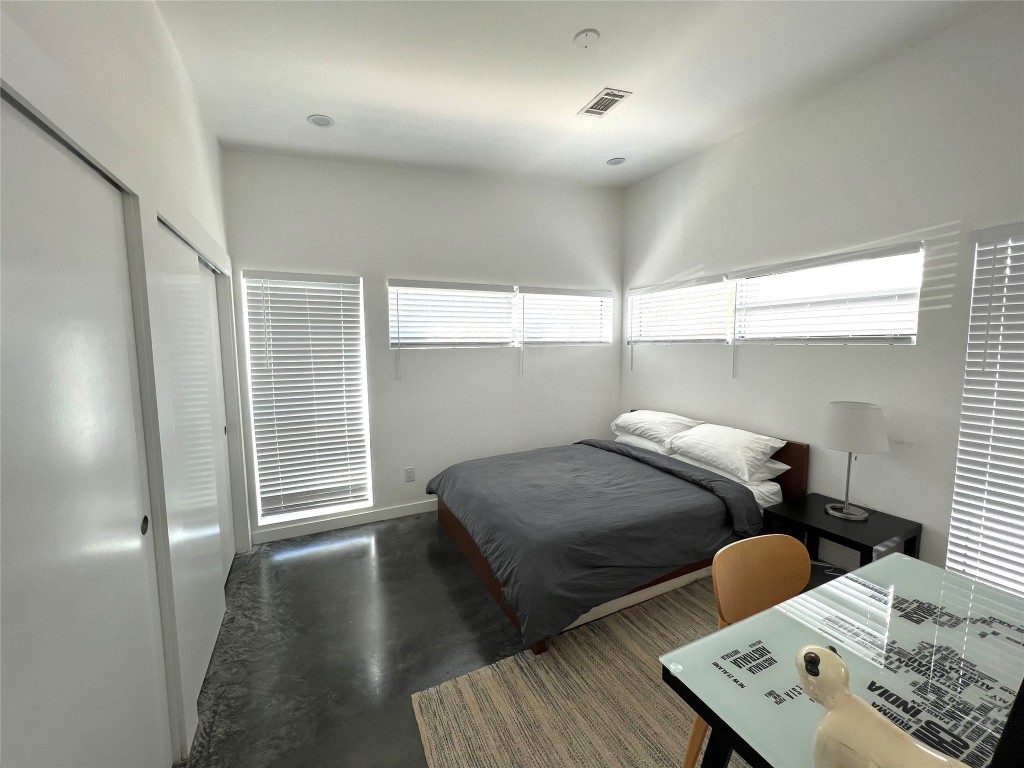 1159 Perry Road, Unit A Austin, TX 78721 - Photo 12 of 23 Bedroom featuring finished concrete floors and a closet