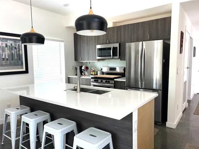 a kitchen with stainless steel appliances a dining table and chairs