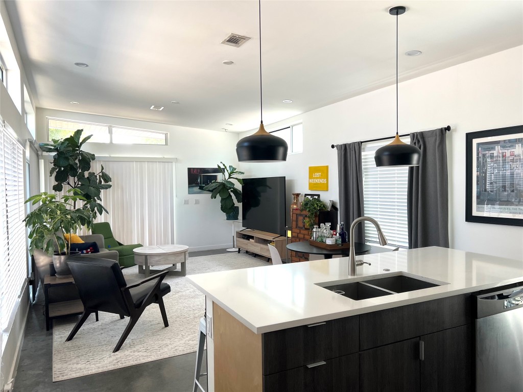 1159 Perry Road, Unit A Austin, TX 78721 - Photo 5 of 23 Kitchen featuring concrete flooring, dishwasher, modern cabinets, pendant lighting, and an island with sink