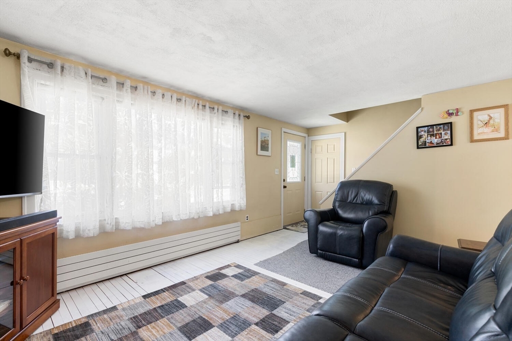 63 Baldwin Road Billerica, MA 01821 - Photo 15 of 38 a living room with furniture and a flat screen tv