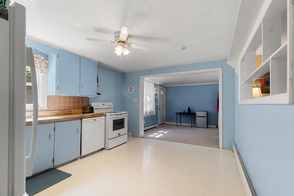 63 Baldwin Road Billerica, MA 01821 - Photo 7 of 38 a large white kitchen with a sink and dishwasher a stove top oven with wooden floor