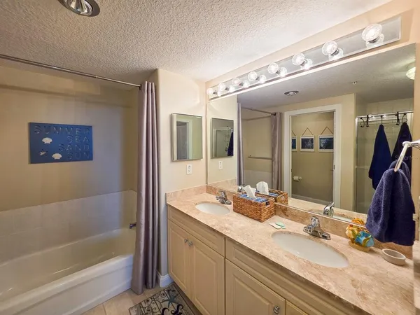 a bathroom with a granite countertop sink mirror vanity and toilet