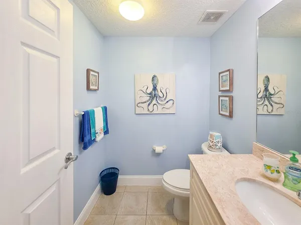a bathroom with a granite countertop sink mirror vanity and toilet