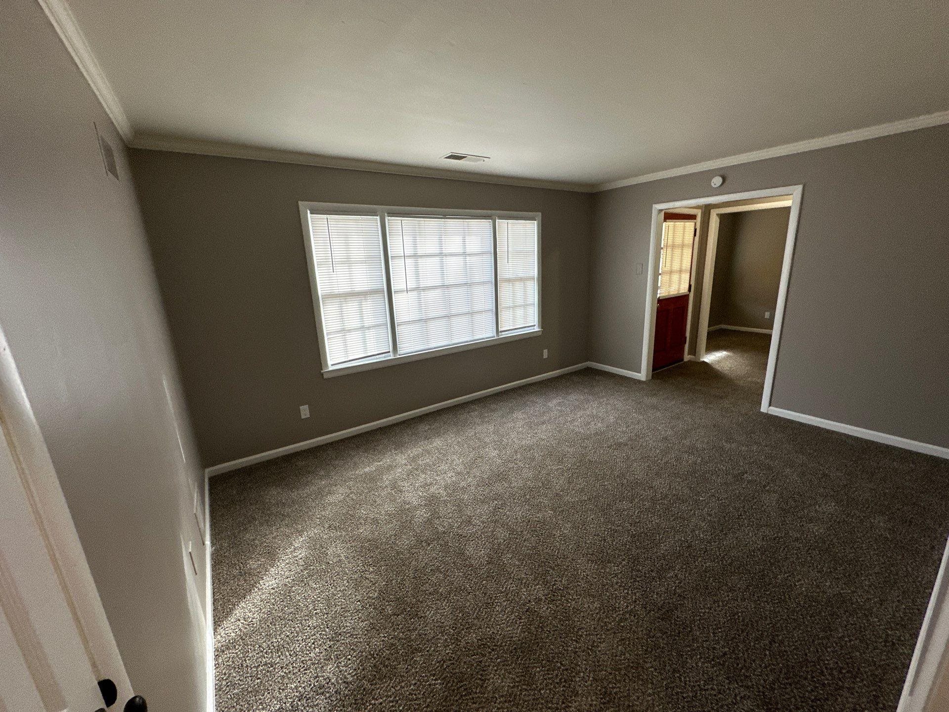 10 West Mitchell Road Memphis, TN 38109 - Photo 6 of 11 Unfurnished room with dark colored carpet, visible vents, baseboards, and crown molding