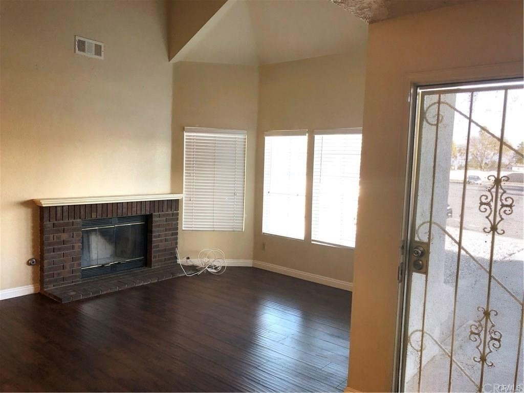 632 North Birch Avenue Rialto, CA 92376 - Photo 2 of 24 an empty room with wooden floor fireplace and windows