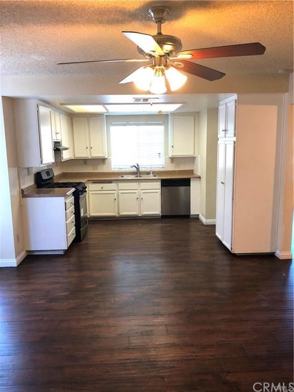 632 North Birch Avenue Rialto, CA 92376 - Photo 4 of 24 a kitchen with stainless steel appliances granite countertop a sink cabinets and wooden floor