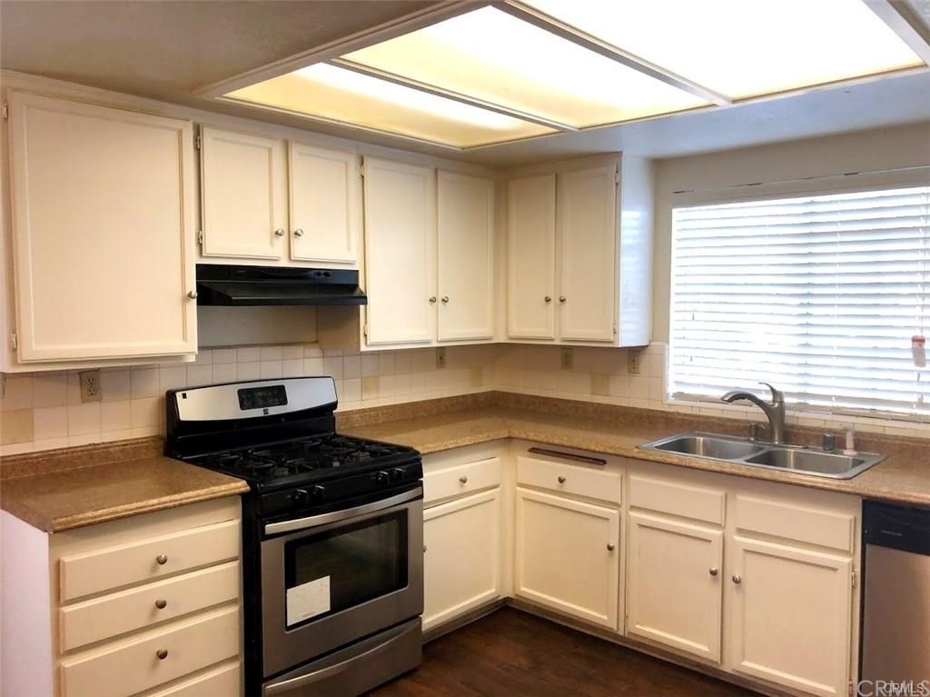 632 North Birch Avenue Rialto, CA 92376 - Photo 5 of 24 a kitchen with granite countertop white cabinets and black appliances