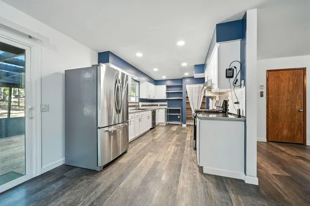 a kitchen with stainless steel appliances a refrigerator and wooden floor