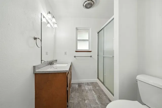 a bathroom with a granite countertop sink toilet and shower