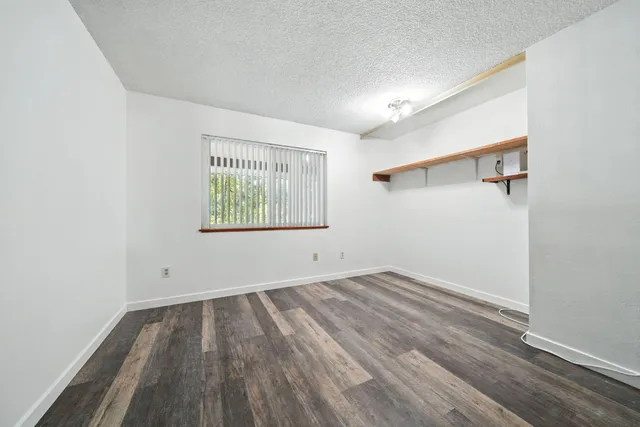 an empty room with a hardwood and ceiling fan