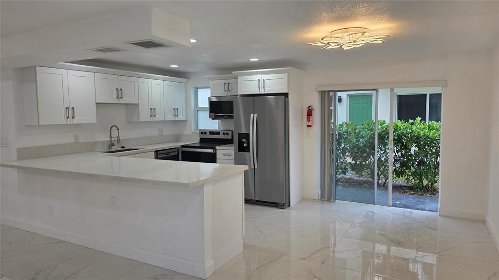 a kitchen with stainless steel appliances a refrigerator sink and stove