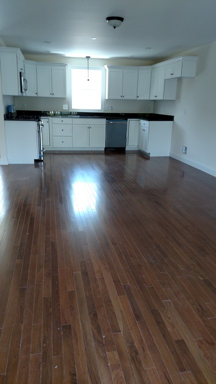 213 Main Street, Unit 2 Maynard, MA 01754 - Photo 8 of 10 a view of an empty room with wooden floor and a window