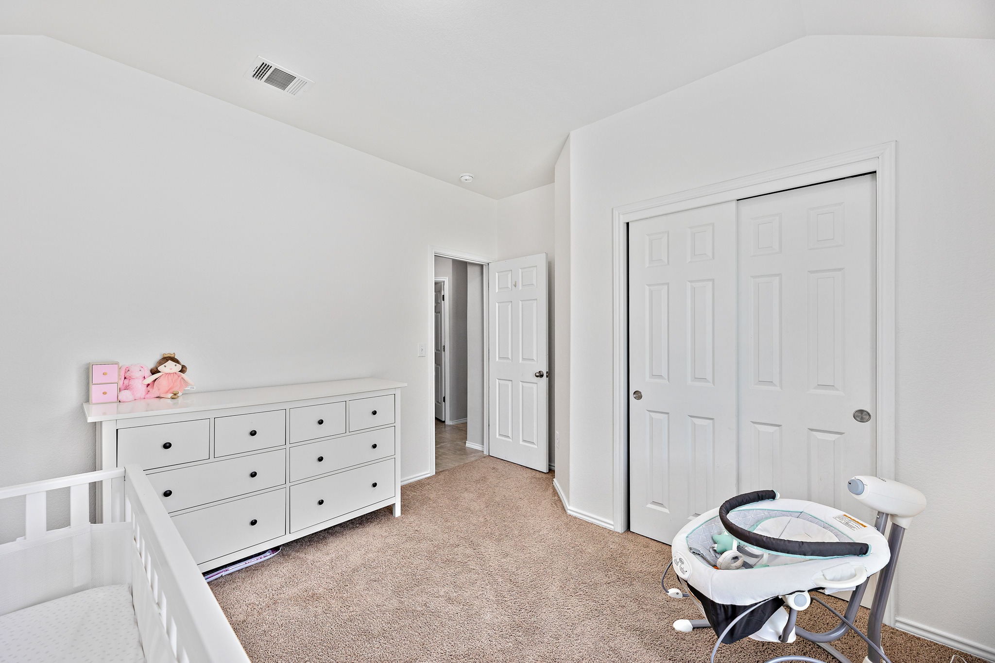 382 Limerick Road Buda, TX 78610 - Photo 11 of 20 A well-lit room boasts plush carpet and ample closet space, providing a versatile living area.