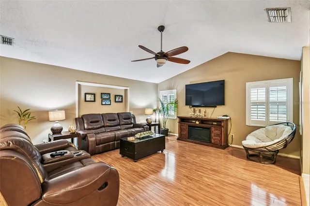 a living room with furniture flat screen tv and wooden floor
