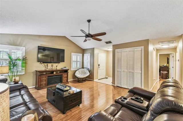 a living room with furniture flat screen tv and a large window