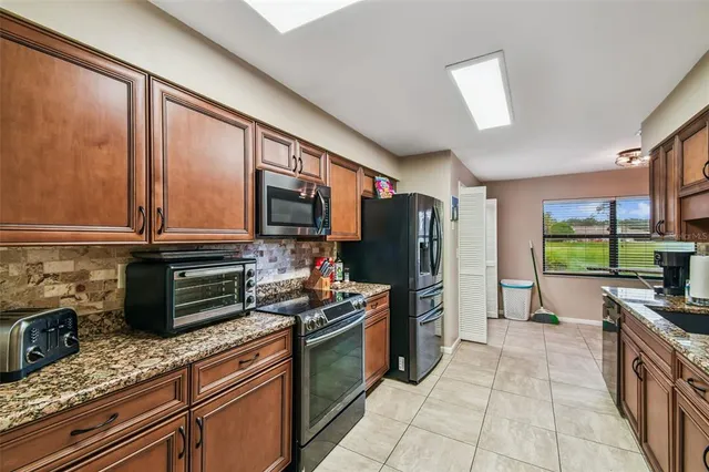 a kitchen with stainless steel appliances granite countertop a refrigerator stove and sink