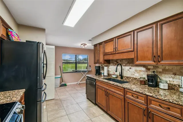 a kitchen with stainless steel appliances granite countertop a refrigerator and a sink