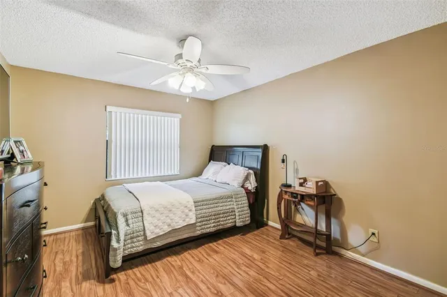 a bedroom with a bed and a ceiling fan