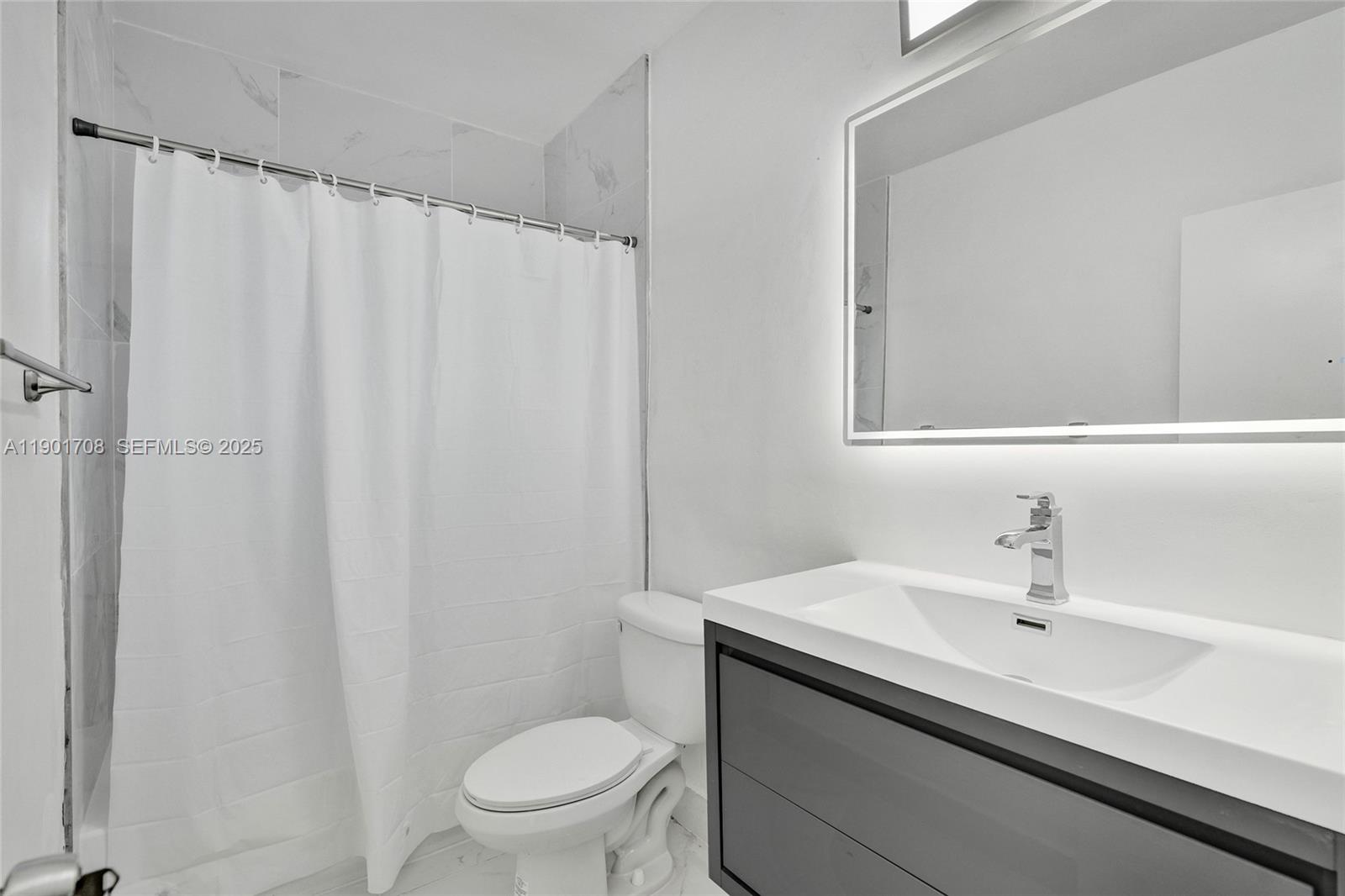 5750 Northwest 111th Street Hialeah, FL 33012 - Photo 16 of 34 a bathroom with a sink a toilet and shower curtain