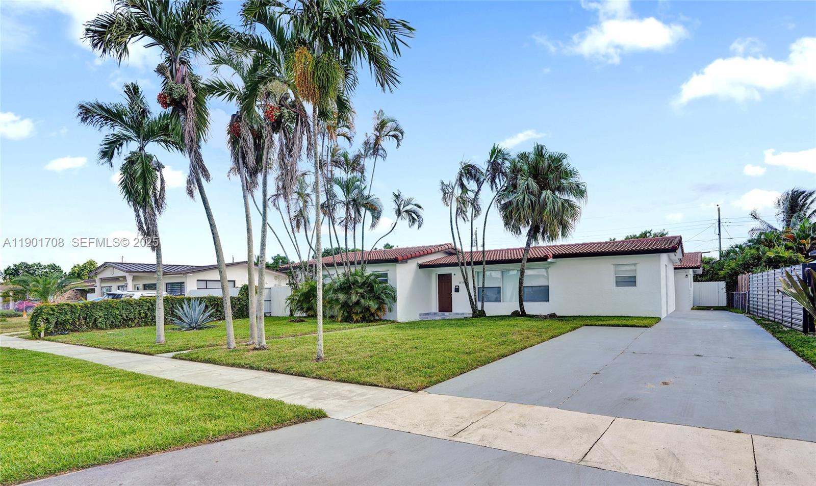 5750 Northwest 111th Street Hialeah, FL 33012 - Photo 29 of 34 a view of a white house with a big yard and palm trees