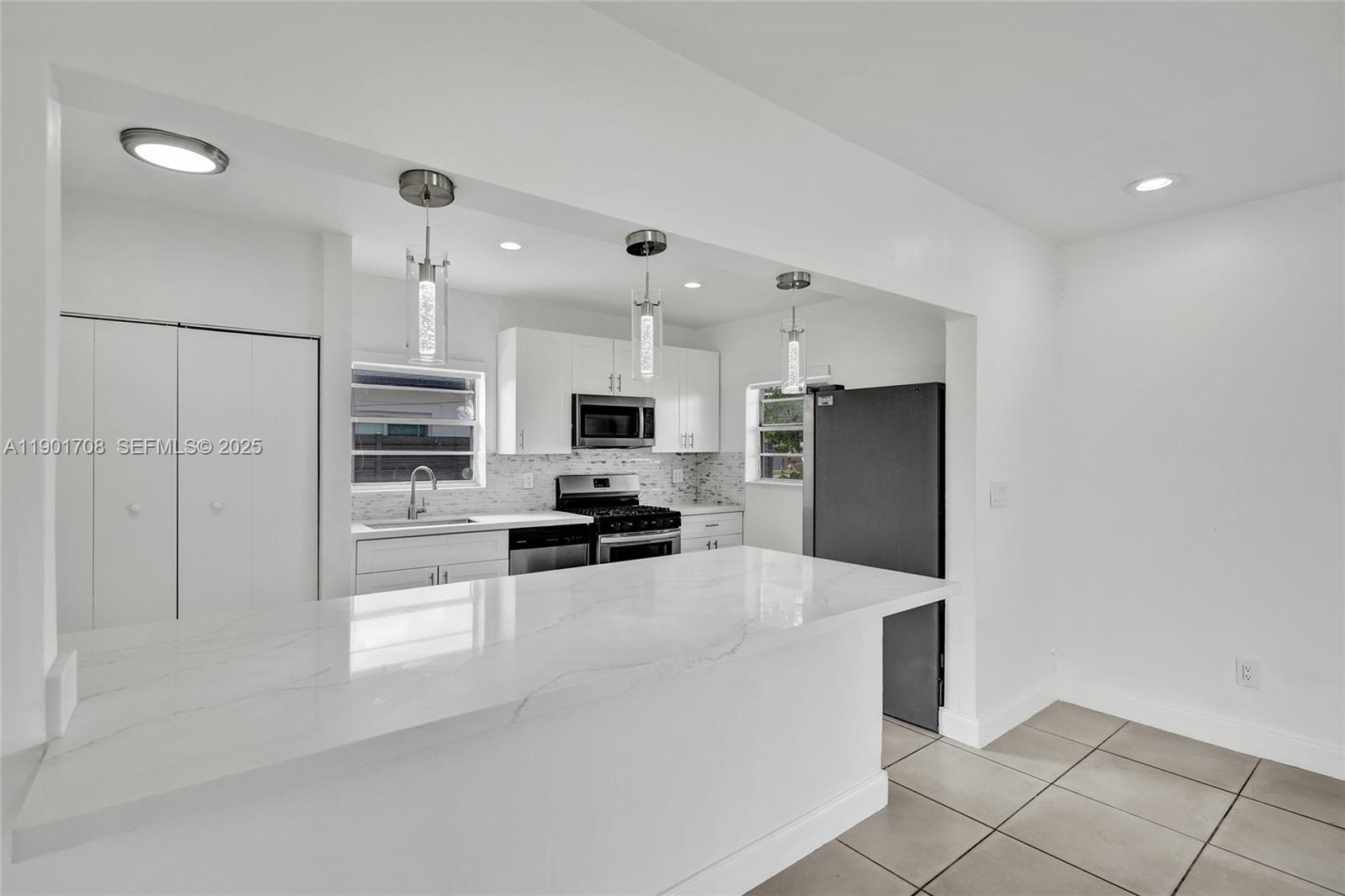 5750 Northwest 111th Street Hialeah, FL 33012 - Photo 4 of 34 a kitchen with stainless steel appliances a refrigerator stove and microwave