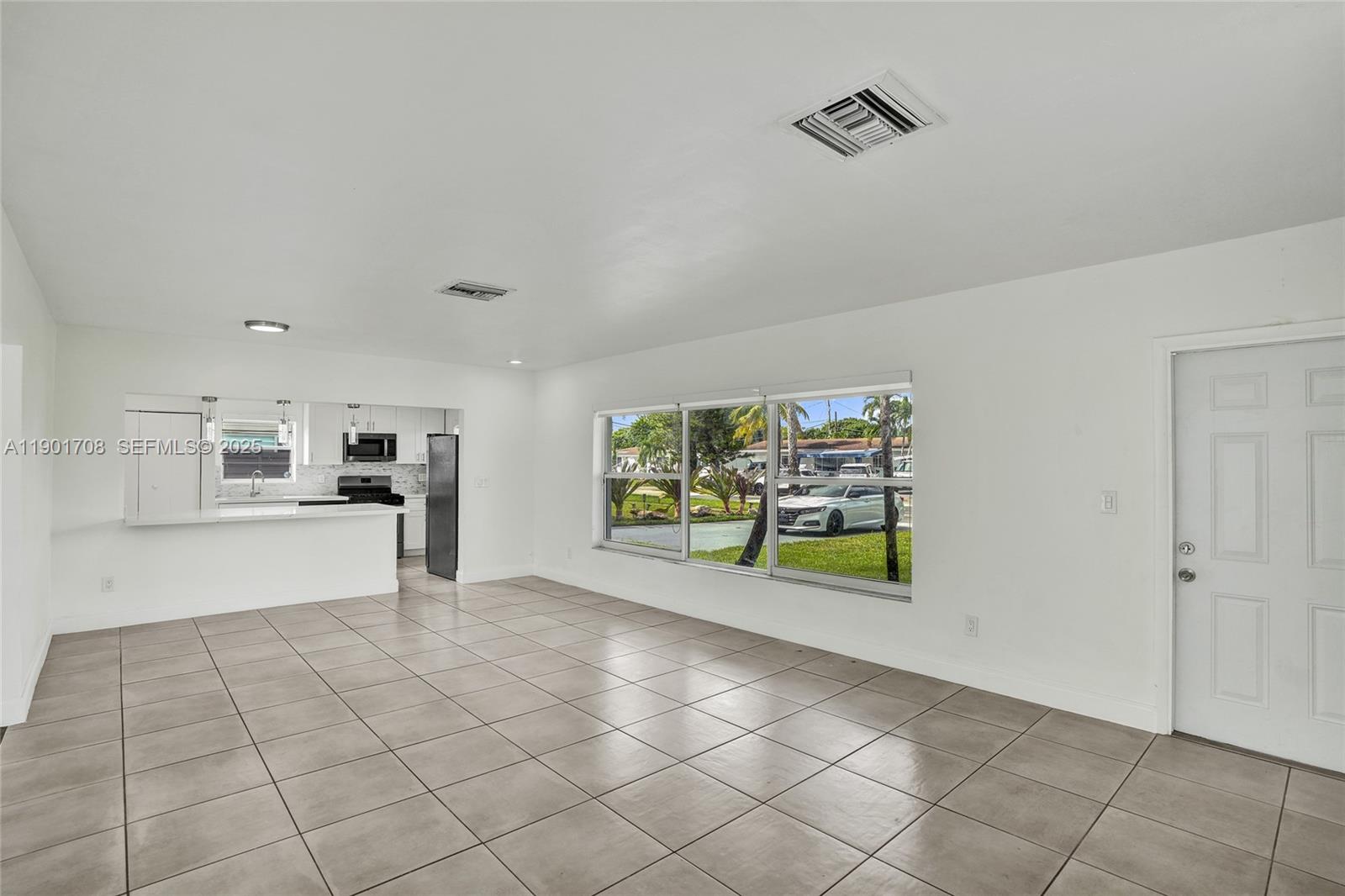 5750 Northwest 111th Street Hialeah, FL 33012 - Photo 6 of 34 a view of an empty room with kitchen and window