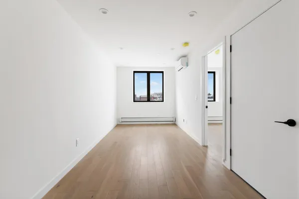 a view of a room with wooden floor and mirror
