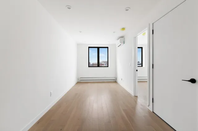 a view of a room with wooden floor and mirror