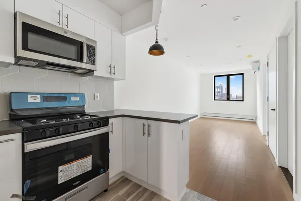 a kitchen with wooden floor a microwave oven and a sink