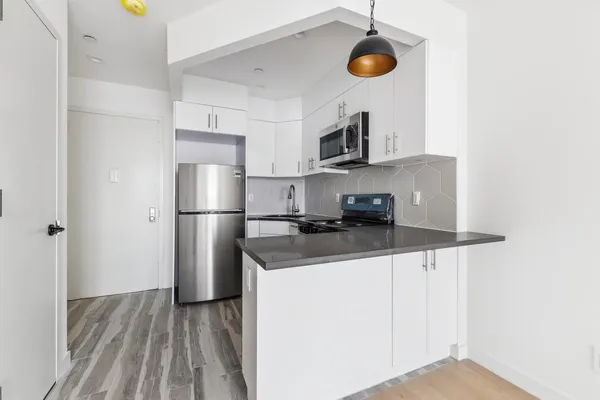 a kitchen with stainless steel appliances granite countertop a sink a stove and a refrigerator