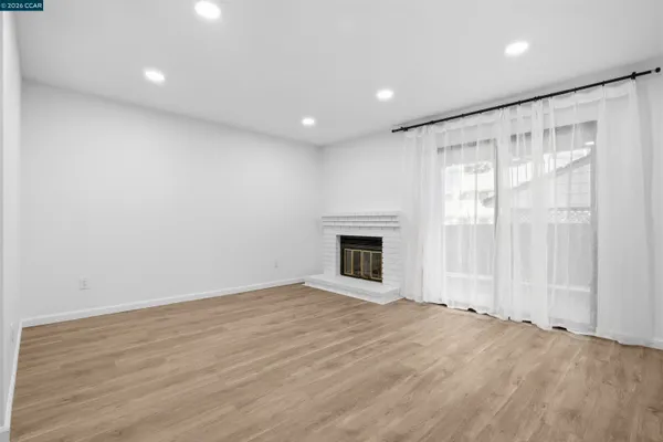 an empty room with wooden floor and fireplace